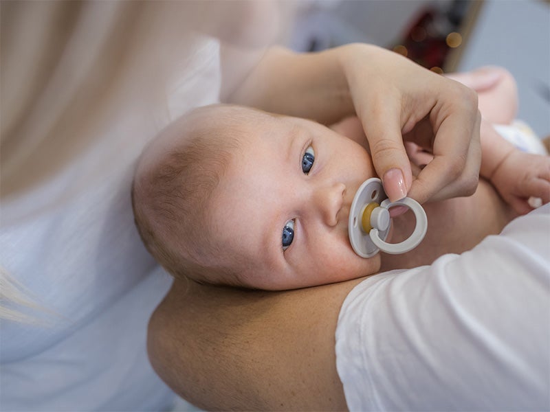 Bebé en brazos con chupete