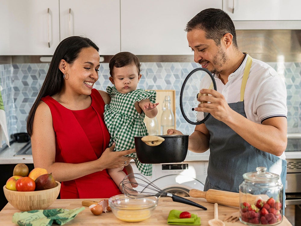 Padres cocinando junto a su bebe